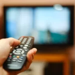Imagem Ilustrativa de um controle remoto sendo apontado para a tv